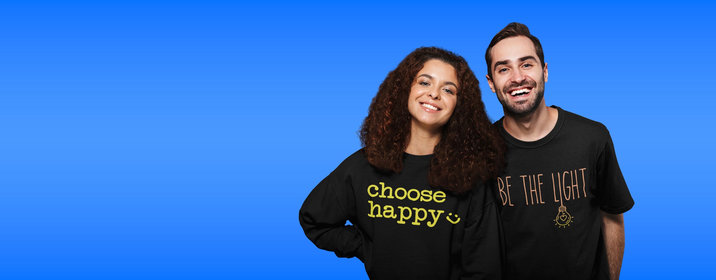 Two people wearing black shirts with motivational phrases on a blue background
