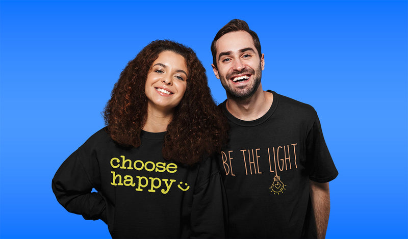 Two people wearing black t-shirts with motivational phrases on a blue background